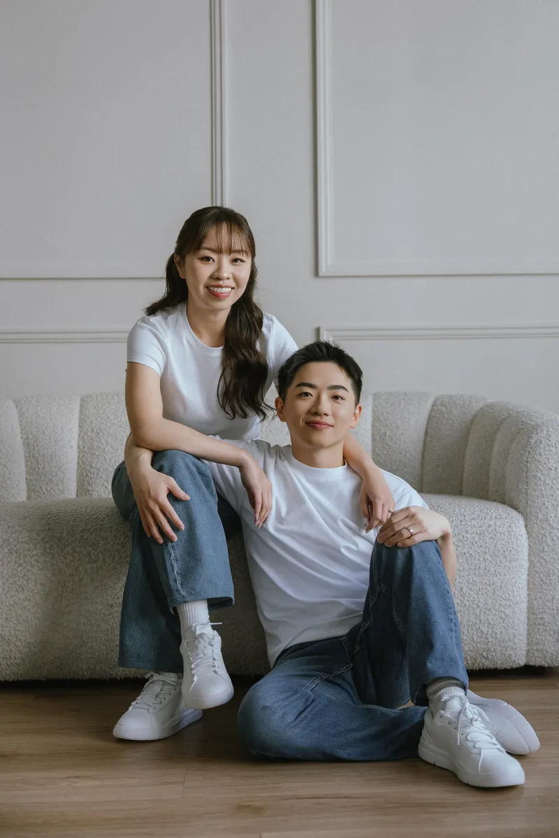 The couple relaxing together on a sofa in a sunlit room.